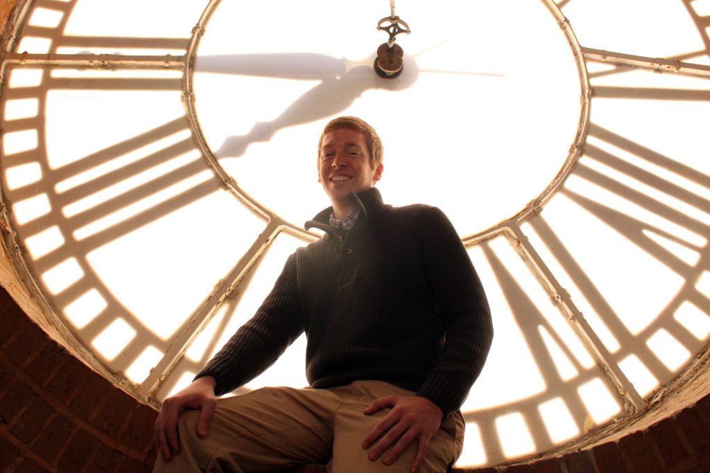 Patrick Vanderjeugdt on the ledge of the clock face inside UNC