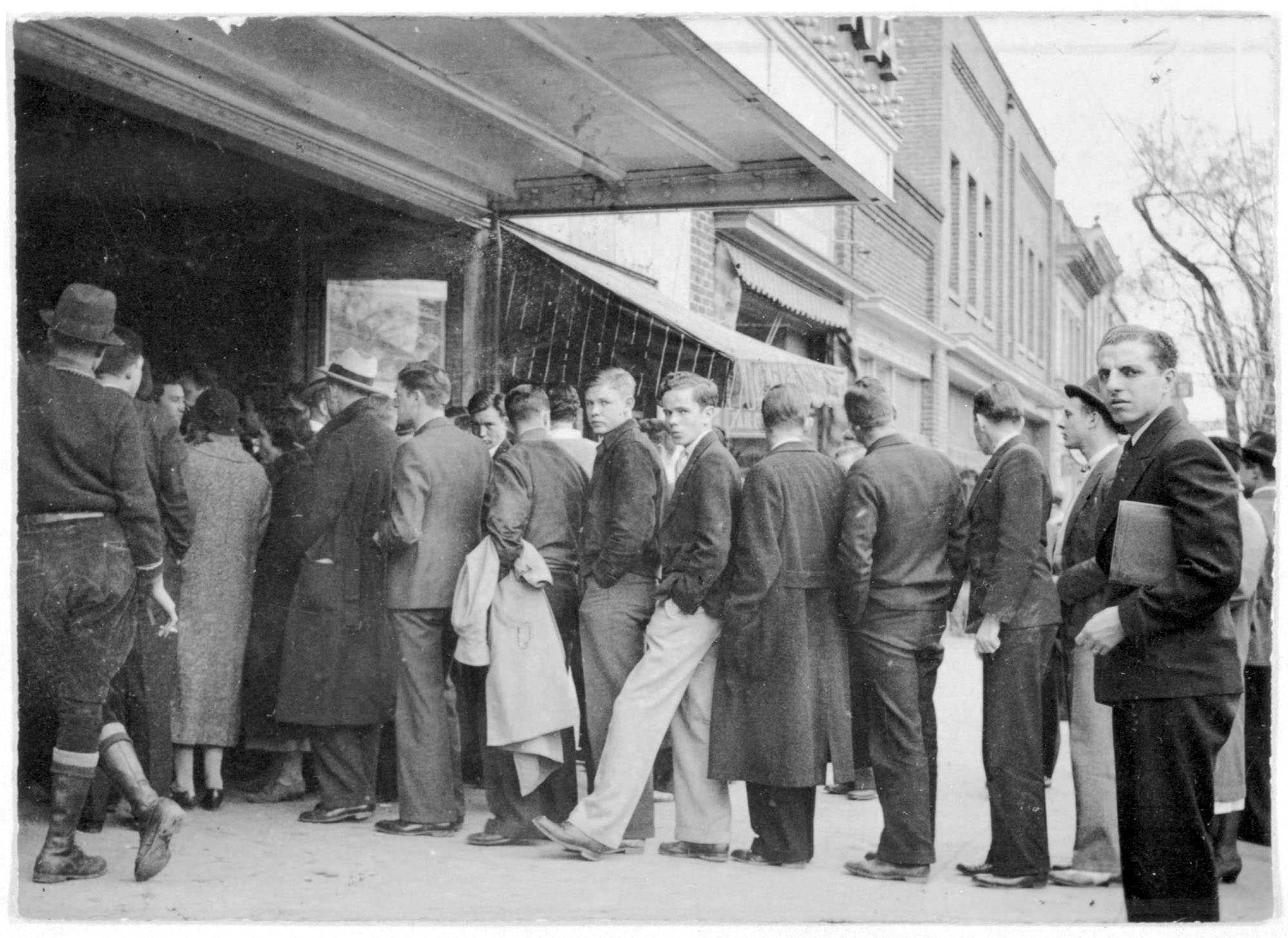 Carolina student walker Percy (light pants, leg extended) waits in line at the Carolina Theater on Franklin St. ca. 1934. (photo courtesy of UNC Libraries)