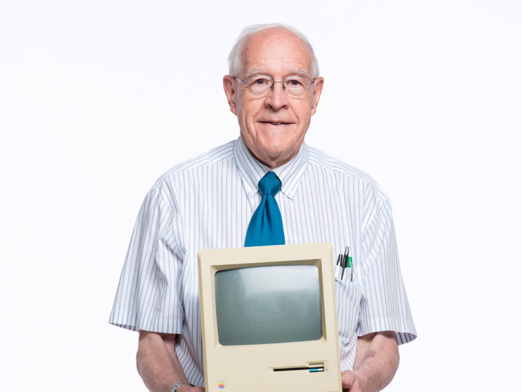 Fred Brooks holds a first-generation Mac.