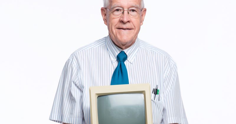 Fred Brooks holds a first-generation Mac.