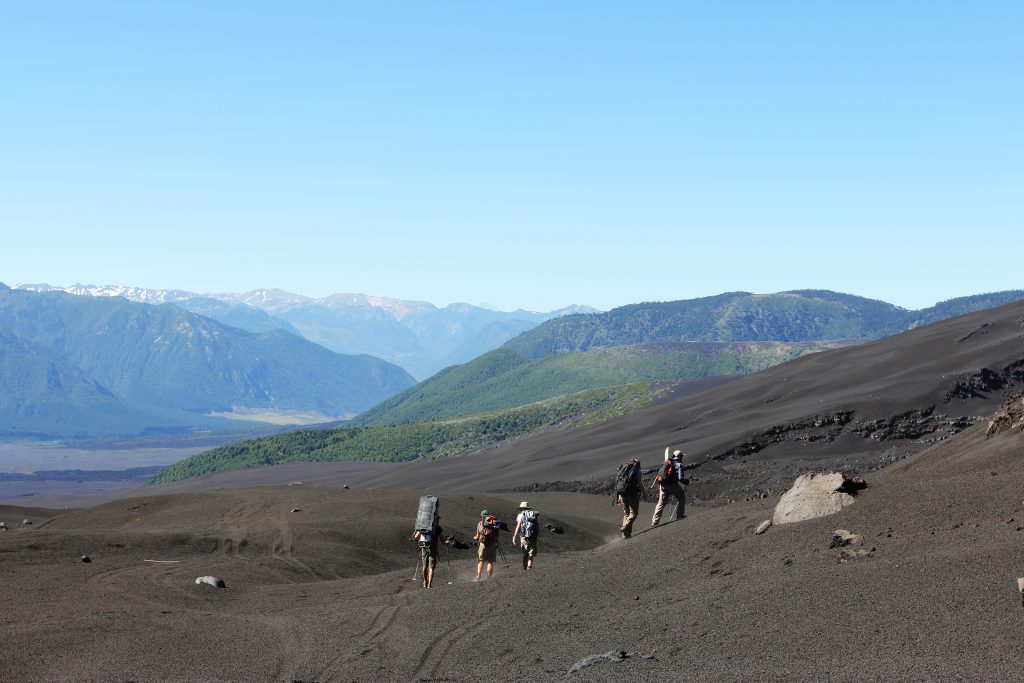 Researchers hike across volcanic ash to install a seismometer on Llaima Volcano in southern Chile.
