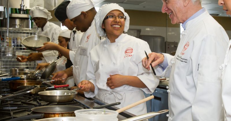 Richard Grausman with students in a kitchen in C-CAP.