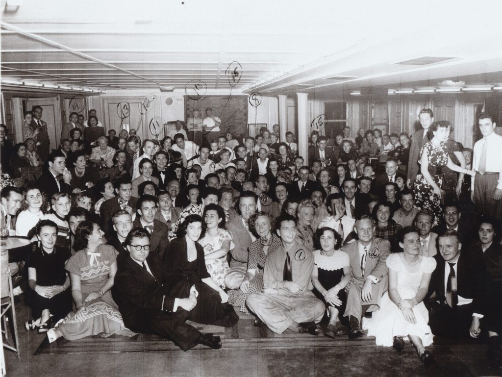 A large group of people pose for a photo taken September 1949 aboard the French Liner SS De Grasse