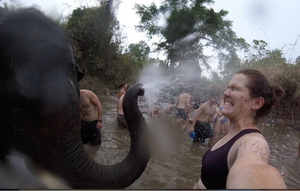 Gabrielle Beaudry takes a selfie as she gets sprayed with water by an elephant