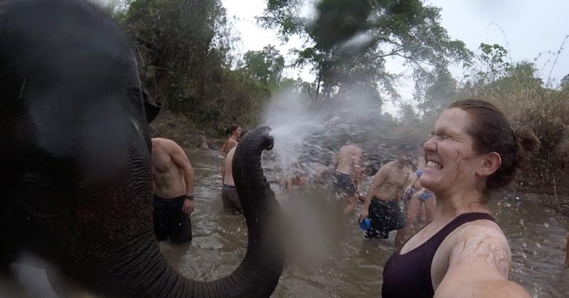 Gabrielle Beaudry takes a selfie as she gets sprayed with water by an elephant