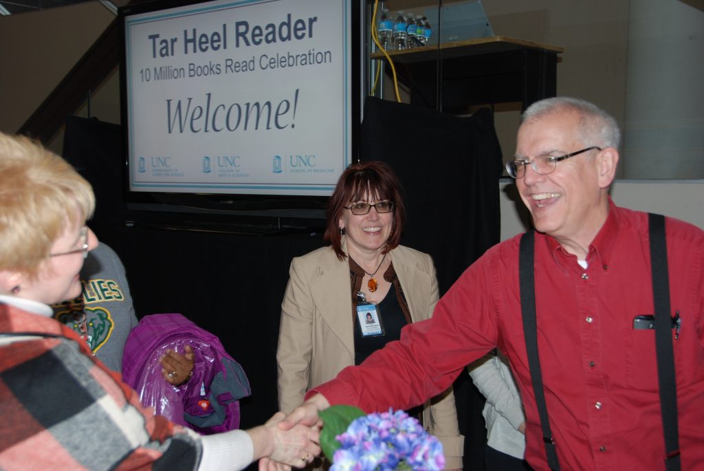 Computer scientist Gary Bishop (right) welcomes a visitor at a celebration marking 10 million books read for Tar Heel Reader,