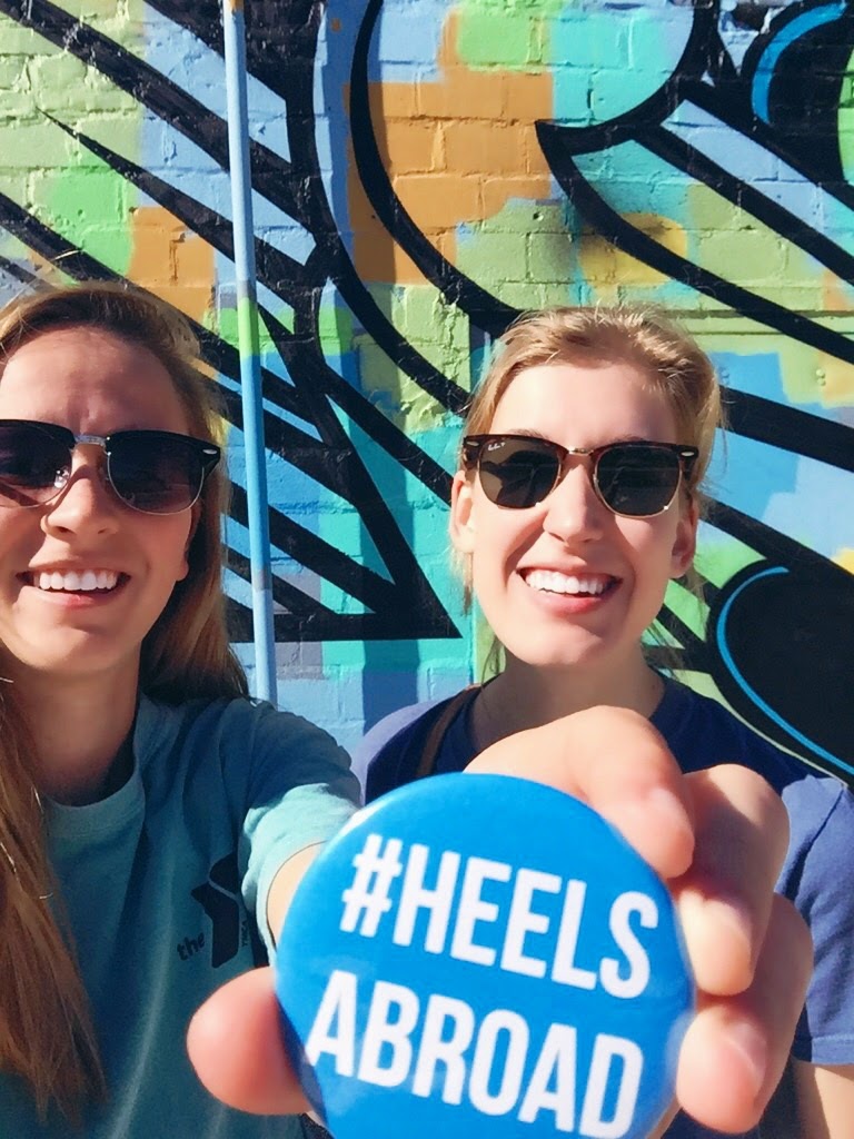 Theresa Jones and Grace Porter hold a button that says #HeelsAbroad