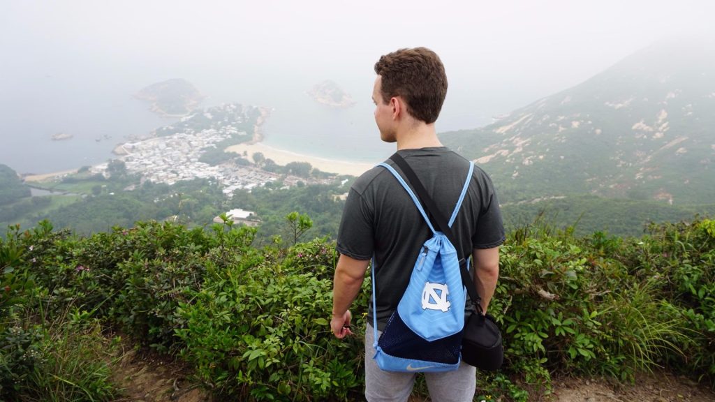 Oliver Jones wears a Carolina backpack at the peak of Dragon's Back hiking trail in Hong Kong