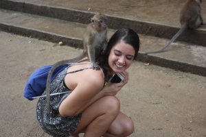 Amanda Davis makes a new friend, a monkey, at a cave temple in Thailand. 