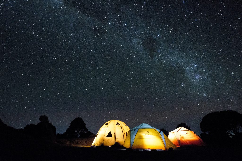 A starry sky above illuminated tents at Mount Kilimanjaro National Park