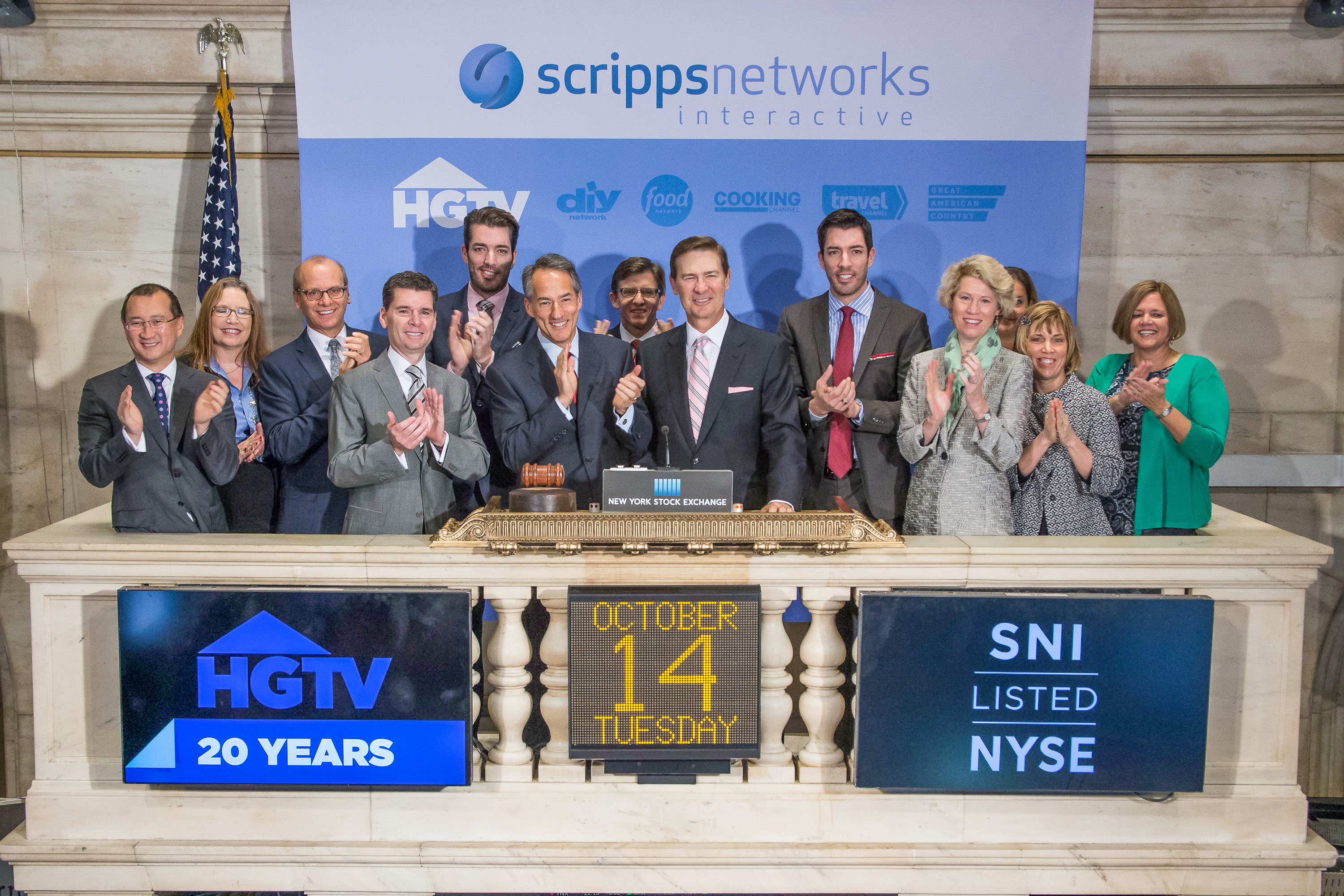 Scripps Networks Interactive Chairman, President and CEO Kenneth Lowe, executive management and HGTV talent Jonathan Scott (L) Drew Scott (R) ring the NYSE opening bell in honor of the 20th Anniversary of HGTV at New York Stock Exchange on October 14, 2014 in New York City.