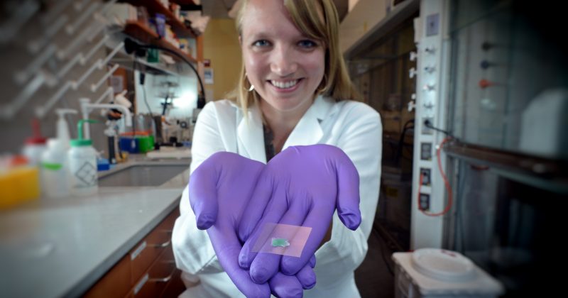 Katie Moga holds an adhesive patch embedded with microneedles which was deisgned to deliver medication painlessly. This is an example of multidisciplinary research known as convergent science.