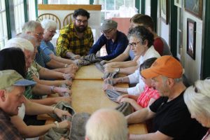 Participants in the inaugural Gaelic Folkways Festival and Summer Institute on Prince Edward Island learn locally-composed Scottish Gaelic songs together with workshop leaders around the milling table. (photo by Heather Mullen)