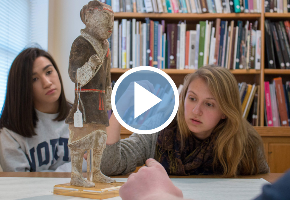 Two students look at an artifact from the Ackland Art Museum for a QEP class.