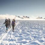 Researchers ski across the Juneau Icefield, carrying shovels