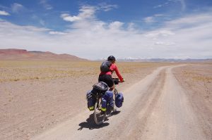 Photo of biker Mel Yule biking the Silk Road with her bicycle loaded down with gear. (Photo by Kate Harris)