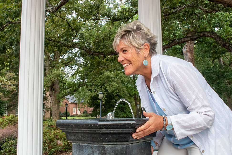 Interim Dean Terry Rhodes takes a sip from the Old Well on the first day of classes.