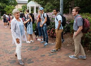 Rhodes greets students lined up for their sip from the Old Well on the first day of classes in fall 2019 (photo: Johnny Andrews).
