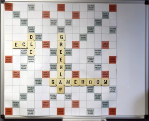 gameboard on the wall in the Greenlaw Gameroom looks like a Scrabble Board with the words Greenlaw Gameroom and ECL and DLC spelled out.