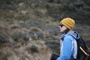 On her first day in the field, Tessa Davis stares in awe at the landscape . She is wearing a yellow hat and warm weather gear.