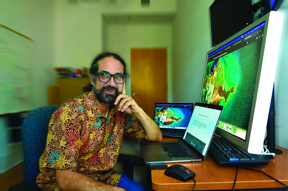 Javier Arce-Nazario sits at his desk in front of his computer.