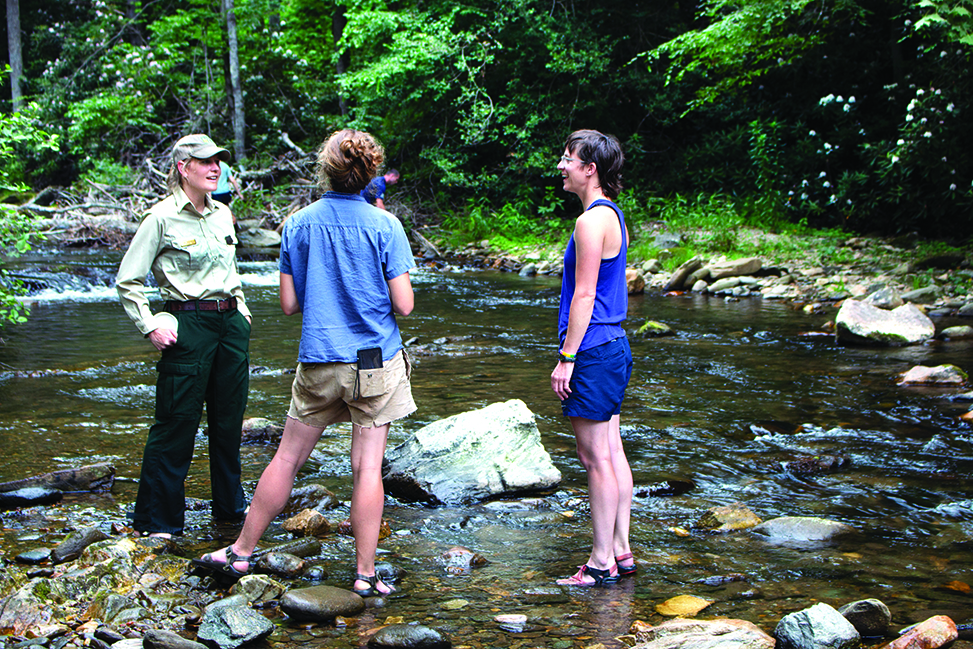A ranger talks to visitors standing in Curtis Creek.