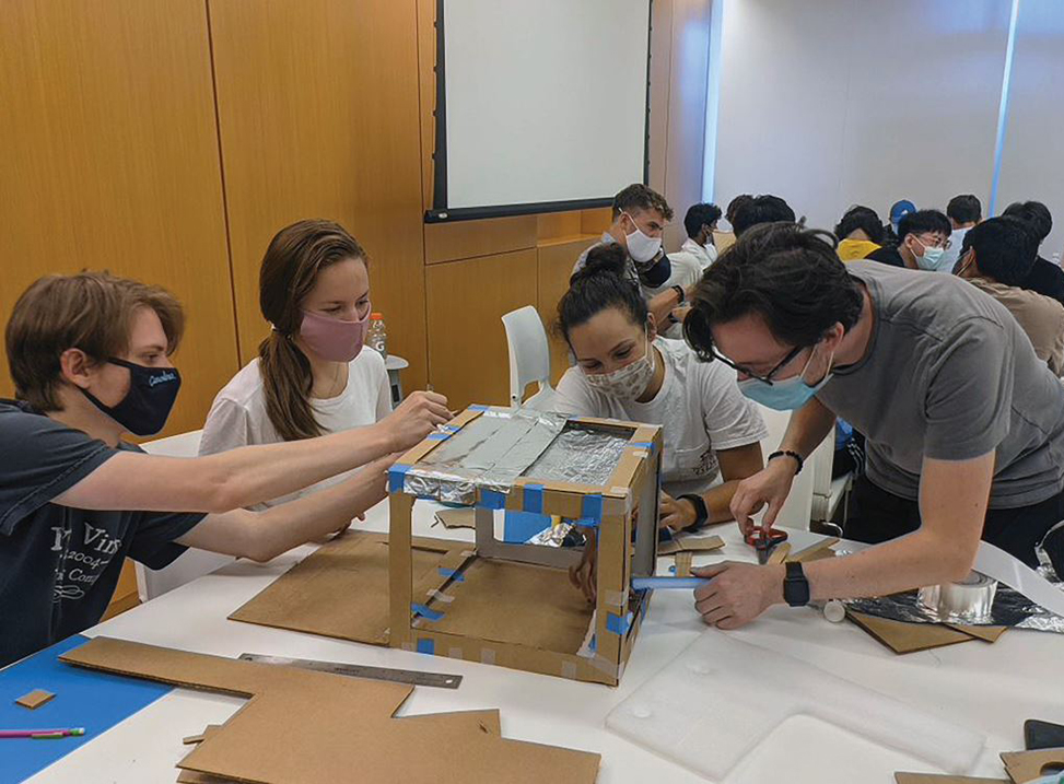 Four engineering students work on a project in the classroom.