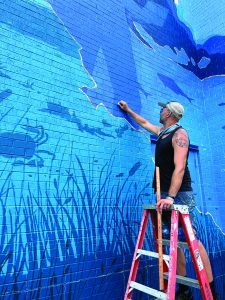 Muralist Max Dowdle in action on the ladder.