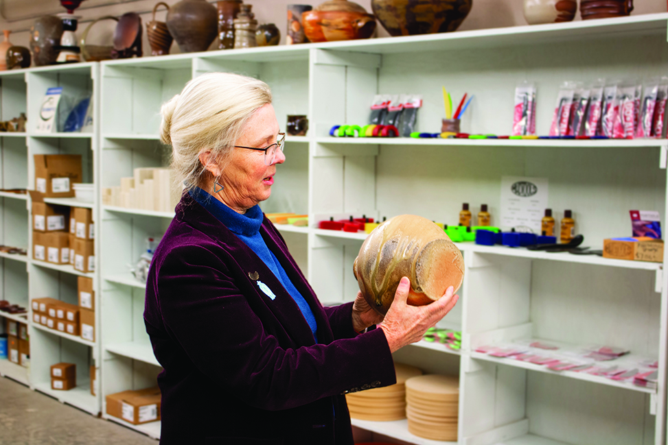 Nancy Gottovi holds a pot that has been fired on its side.