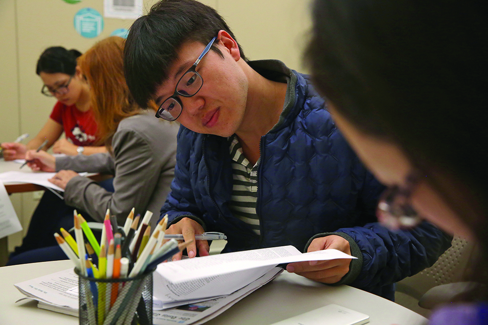 A student flips through a notebook as he is tutored by another student in the Writing and Learning Center.