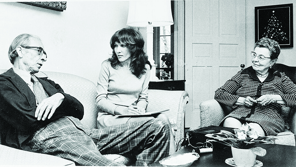 Left to right: Guy Johnson and Jacquelyn Dowd Hall on a couch and Guion Johnson on a chair in a living room. In black and white.