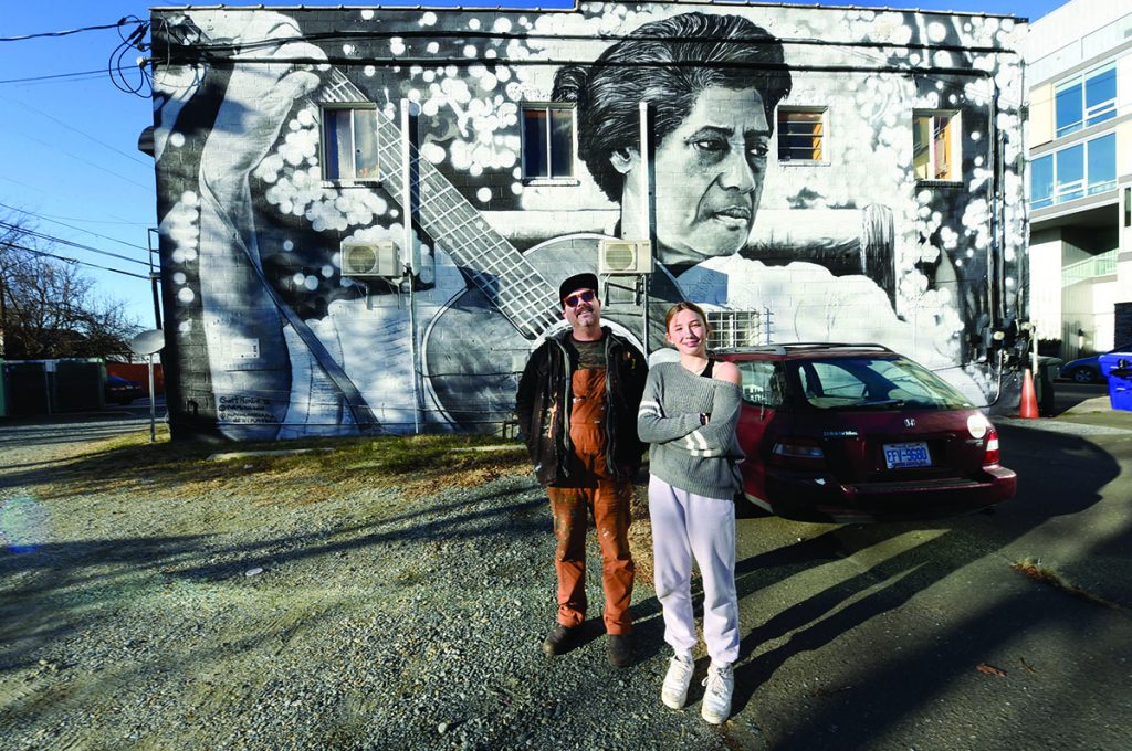 Scott Nurkin and daughter Finch stand in front of the Elizabeth Cotten mural in Carrboro.