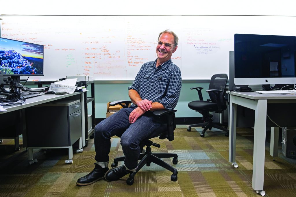 Daniel Anderson sits in a chair in a computer lab on UNC's campus